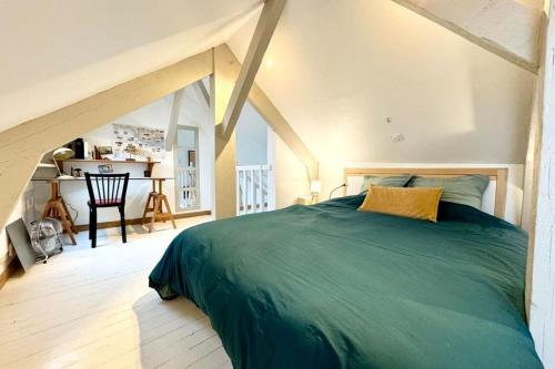 - une chambre mansardée avec un grand lit vert dans l'établissement Charmant duplex en bord de mer - Port de Kernevel, à Larmor-Plage