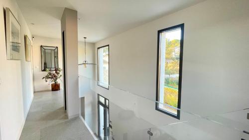 - un couloir avec deux fenêtres dans une maison dans l'établissement Maison La pause Contemporaine et Piscine Privée, à Lambesc