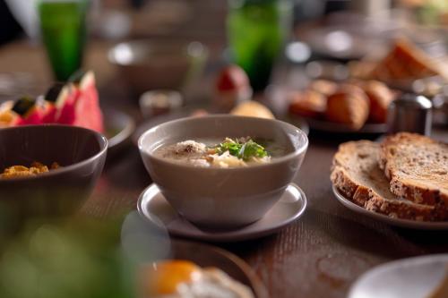 een tafel met een kom soep en brood bij Pakasai Resort in Ao Nang Beach