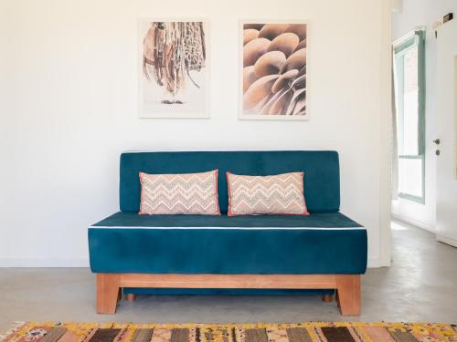 a blue couch in a living room with two pillows at חאן טשרניחובסקי in ‘Ofer