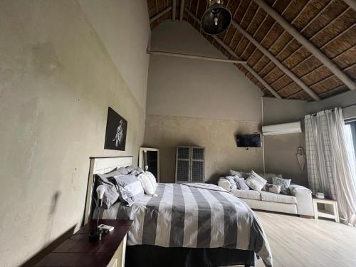 a bedroom with a bed and a couch in it at Simba Safaris African Pride Exotic Lodge in Lephalale