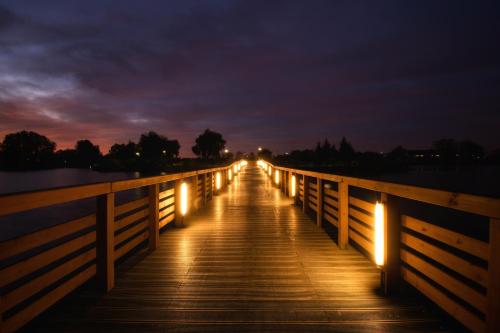 a wooden bridge at night with lights on it at Centrum One in Suwałki