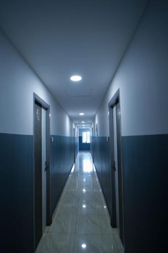 a corridor of a restroom with blue walls and doors at HOTEL RAAJ GRAND in Chennai
