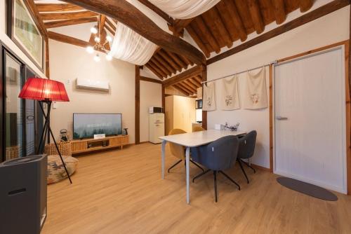a living room with a table and chairs and a television at Gangneung Mokgawon in Kangmun