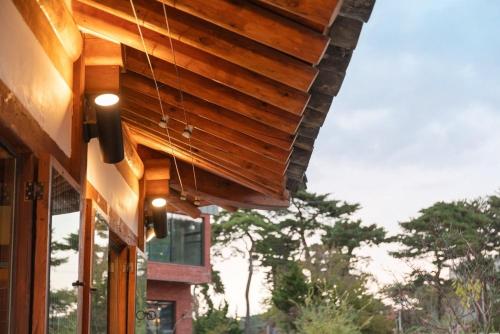 a building with a wooden roof with a window at Gangneung Mokgawon in Kangmun