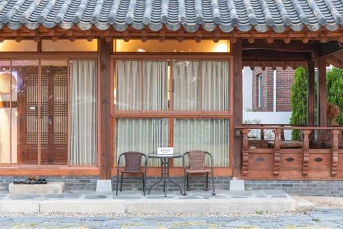 a patio with two chairs and a table in a building at Gangneung Mokgawon in Kangmun