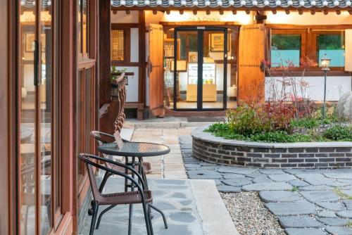 a patio with a table and chairs in front of a building at Gangneung Mokgawon in Kangmun