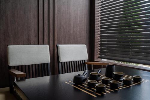a dining room table with black cups and chopsticks at Hoshiga Pool Villa in Yeongcheon