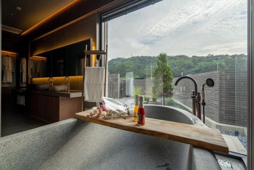 a bathroom with a bath tub with a large window at Hoshiga Pool Villa in Yeongcheon