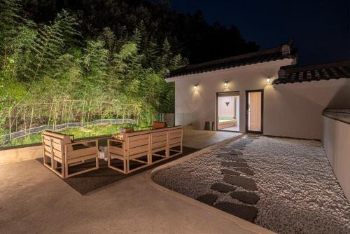 a patio with a table and chairs in front of a house at Hoshiga Pool Villa in Yeongcheon
