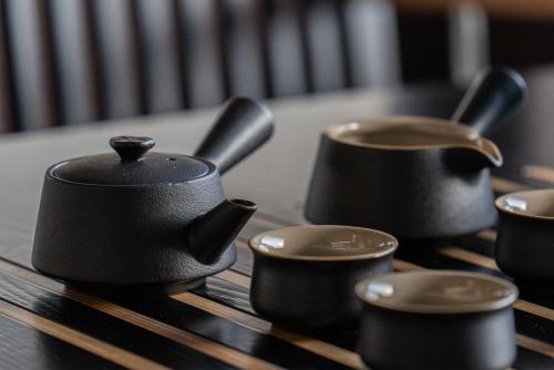 a group of black pots and cups on a table at Hoshiga Pool Villa in Yeongcheon