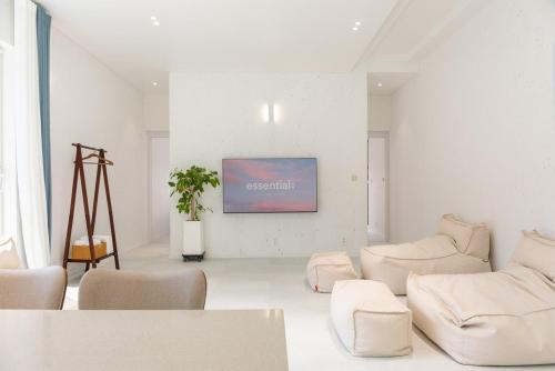 a living room with white furniture and a painting on the wall at Gangneung Dao Pool Villa in Gangneung