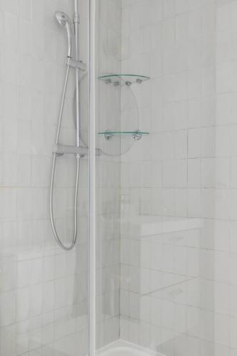 une douche avec une porte vitrée dans une salle de bain dans l'établissement An Enchanting Parisian hideaway, à Paris