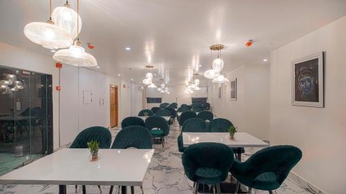a room with rows of tables and green chairs at PerfectStayz Premium Cadillac in Varanasi