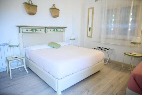 a white bedroom with a white bed and two tables at Etna Casa del Sole in Nicolosi