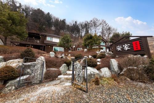 an open gate in a yard with a house at Hongcheon Anga Inn Pension in Hongcheon