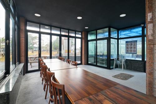 Una gran sala de conferencias con una mesa larga y sillas. en Play here too Pool villa, en Ansan