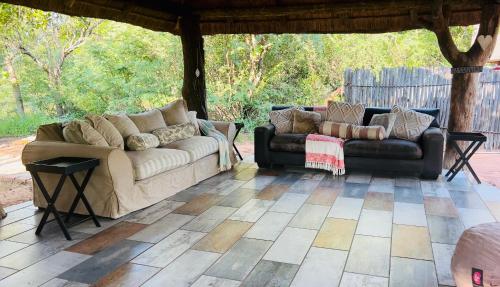 a living room with two couches on a patio at Simba Safaris African Pride Exotic Lodge in Lephalale