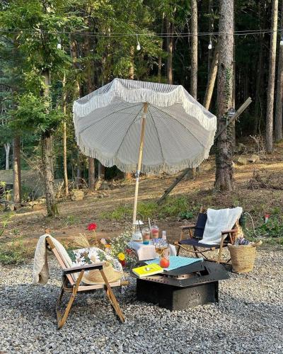 an umbrella and chairs and a table and a table and chairs at Tivoliville Spa N Poolvilla in Pocheon