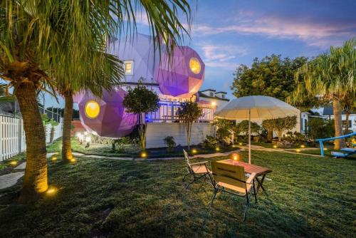 a table and chairs and an umbrella in a yard at Atto Pension in Sinhŭng il-li