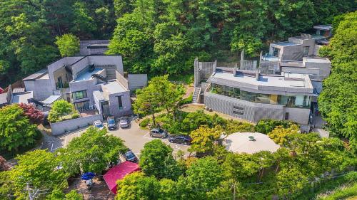 an aerial view of a large house with a parking lot at Yang Pyeong HOUSE OF MIND pension in Yangpyeong