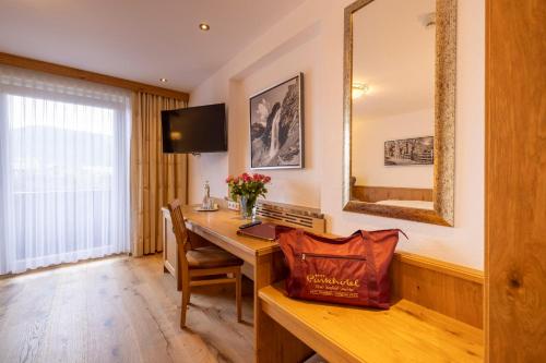 a room with a desk with a computer and a mirror at Parkhotel Seefeld in Seefeld in Tirol