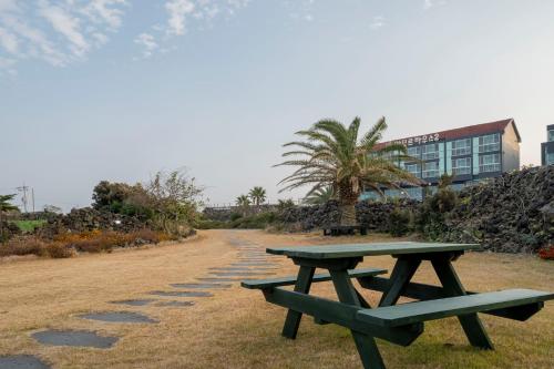 a picnic table sitting next to a road with a building at Jeju Amor House Oceanview Oreum in Jeju