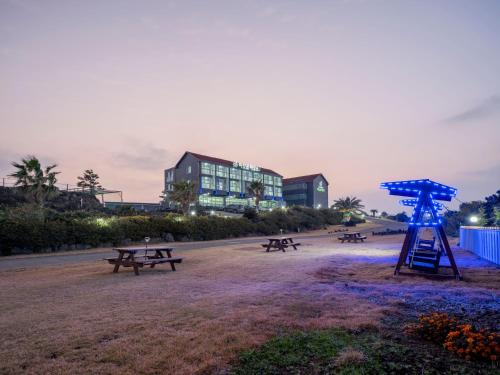a group of picnic tables in a park at night at Jeju Amor House Oceanview Oreum in Jeju