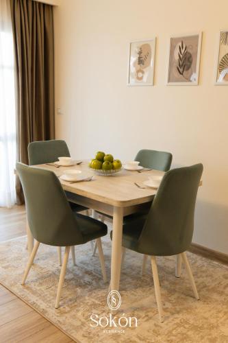 a wooden table with chairs and a bowl of fruit on it at Sokon Residence Madinaty in Madinaty