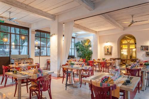 a restaurant with wooden tables and red chairs at Le Grand Hôtel in Molitg les Bains