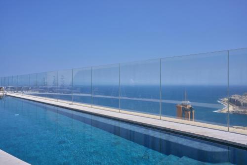 a swimming pool with a view of the ocean at Sky High Luxury Apartment in Mercury Towers with Infinite Seaviews in St. Julianʼs