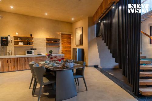 a kitchen and dining room with a table and chairs at StayVista at Urban Escape - 2 Pools, Lawn & WiFi in Jaipur