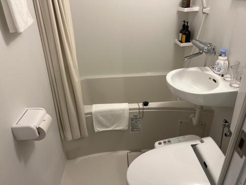 a small bathroom with a toilet and a sink at Living Inn Nahakoumae in Naha
