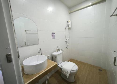 a white bathroom with a sink and a toilet at Ban Ye in Phayao