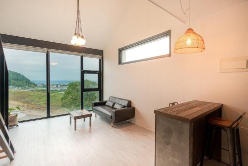 una sala de estar con un sofá y una silla en Trip Recipe, en Sinŏm-ni