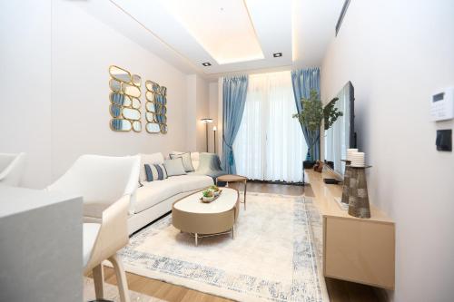 a living room with a white couch and a table at One Bedroom Luxury Apartment at The Diamond in the City in Accra