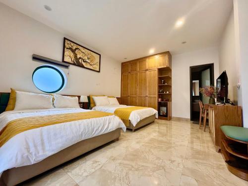 a hotel room with two beds and a mirror at Plum Village Moc Chau in Mộc Châu