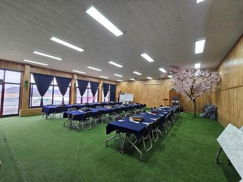 a banquet hall with blue tables and chairs and a tree at Paju Salimchae Pension in Paju