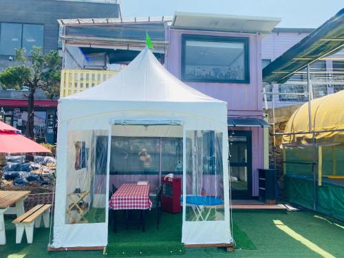 a white tent with a table in front of a building at Paju Salimchae Pension in Paju