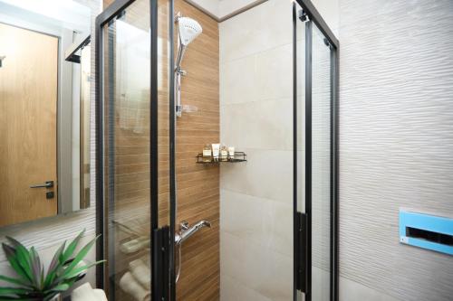a shower with a glass door in a bathroom at One Bedroom Luxury Apartment at The Diamond in the City in Accra