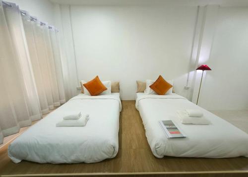 two beds sitting next to each other in a room at Ban Ye in Phayao