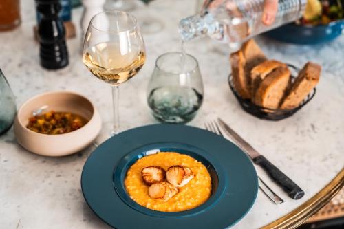 a table with a plate of food and glasses of wine at Fahrenheit Seven Courchevel in Courchevel