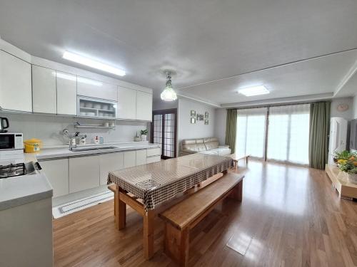 a large kitchen with a table in the middle of it at Jeju Casalinda in Myŏngwŏl