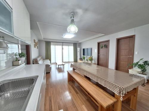 a living room with a table in the middle at Jeju Casalinda in Myŏngwŏl
