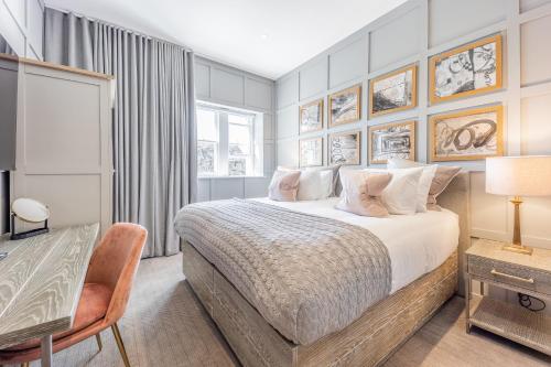 a bedroom with a bed and a table and a desk at No1 Apartments St Andrews - South Street in St. Andrews