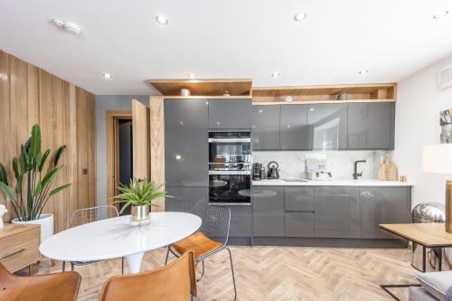 a kitchen and dining room with a white table and chairs at No1 Apartments St Andrews - South Street in St. Andrews