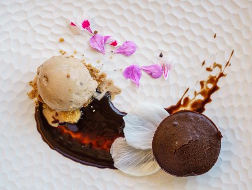 a chocolate ice cream and some purple flowers on a plate at Rivage Hotel Restaurant Lutry in Lausanne