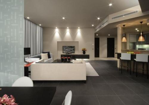 a living room with a white couch and a kitchen at The Abdali Boulevard Hotel in Amman