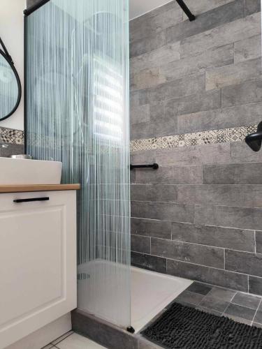 une douche avec une porte vitrée dans une salle de bain dans l'établissement T2, 10min centre historique, clim, jardin, parking, à Avignon