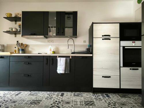 une cuisine avec des armoires grises et un évier dans l'établissement T2, 10min centre historique, clim, jardin, parking, à Avignon